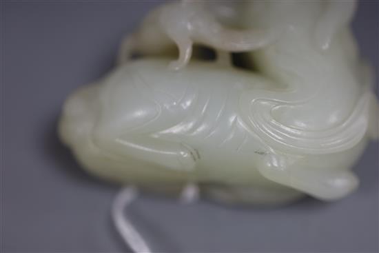 A Chinese pale celadon jade figure of a lion dog and cub, 18th/19th century, L. 6cm, wood stand